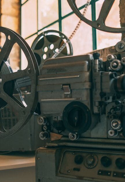 Close-up of a vintage film projector in a rustic, dimly lit room with stone walls.
