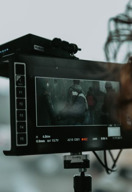 A close-up of professional filming equipment capturing a scene outdoors.