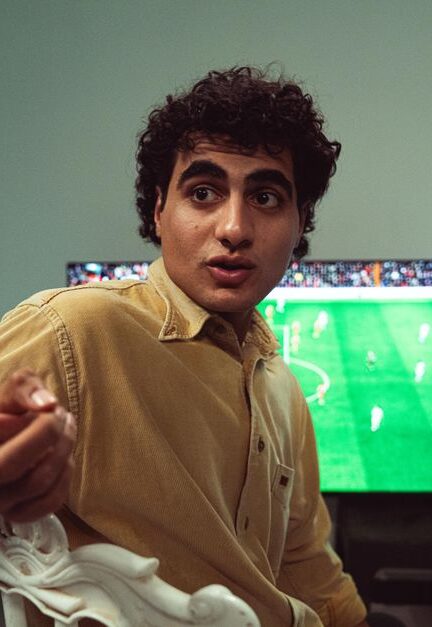 A man engaged in watching a soccer game on TV, expressing emotions.