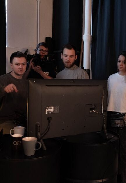 A group collaborates on a video production project in a studio setting.